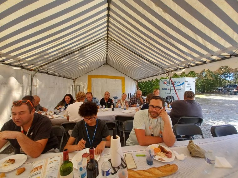 Le repas de midi sous le barnum, adhérents et visiteurs à table